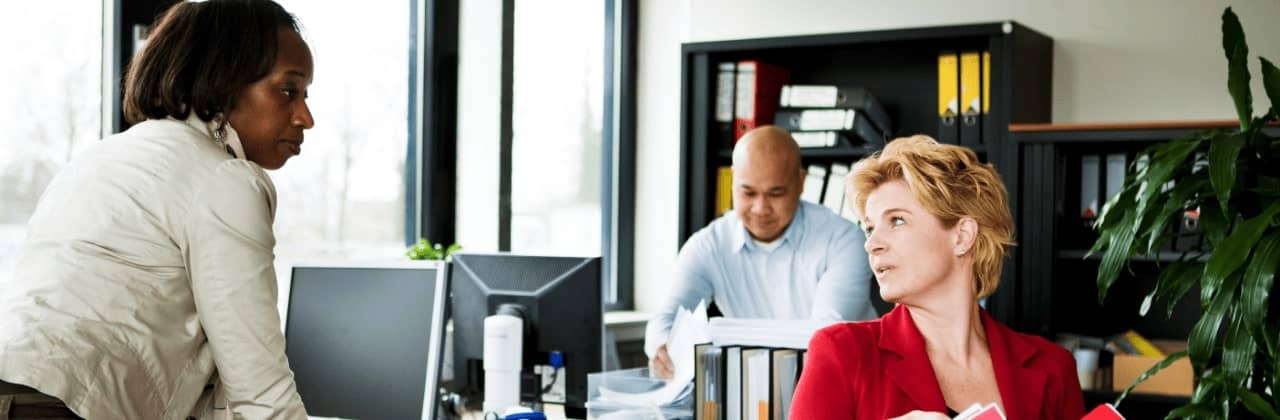Three people sitting in the office