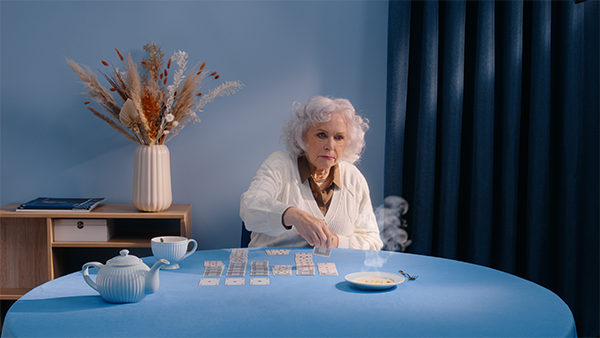 Oude vrouw aan tafel speelt patience