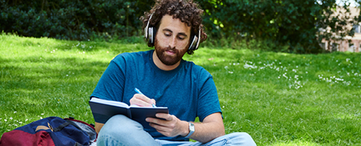 man sitting in the park with his headphones on