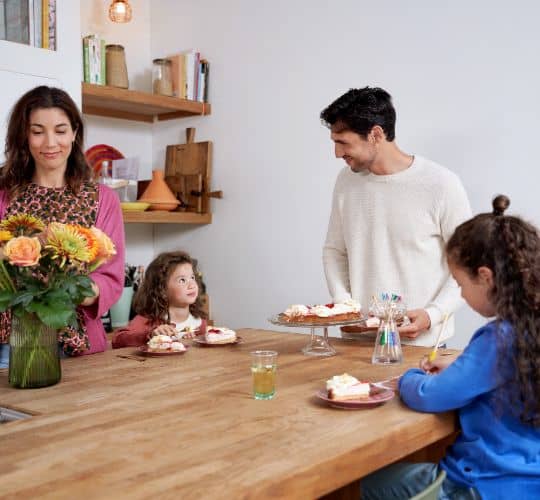 man en vrouw samen met kinderen aan tafel taart eten
