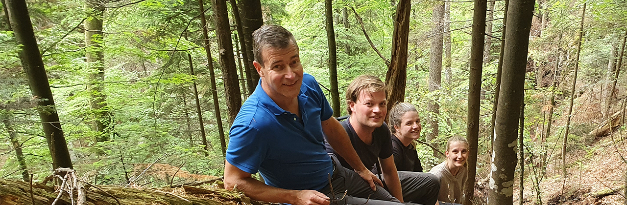 Hoogleraar Gert-Jan Nabuurs met promovendi in het bos